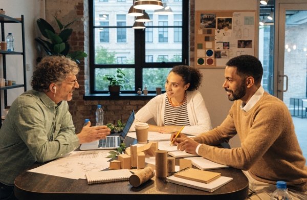 DTC brand team discussing and reviewing sustainable compliant packaging prototypes in a meeting